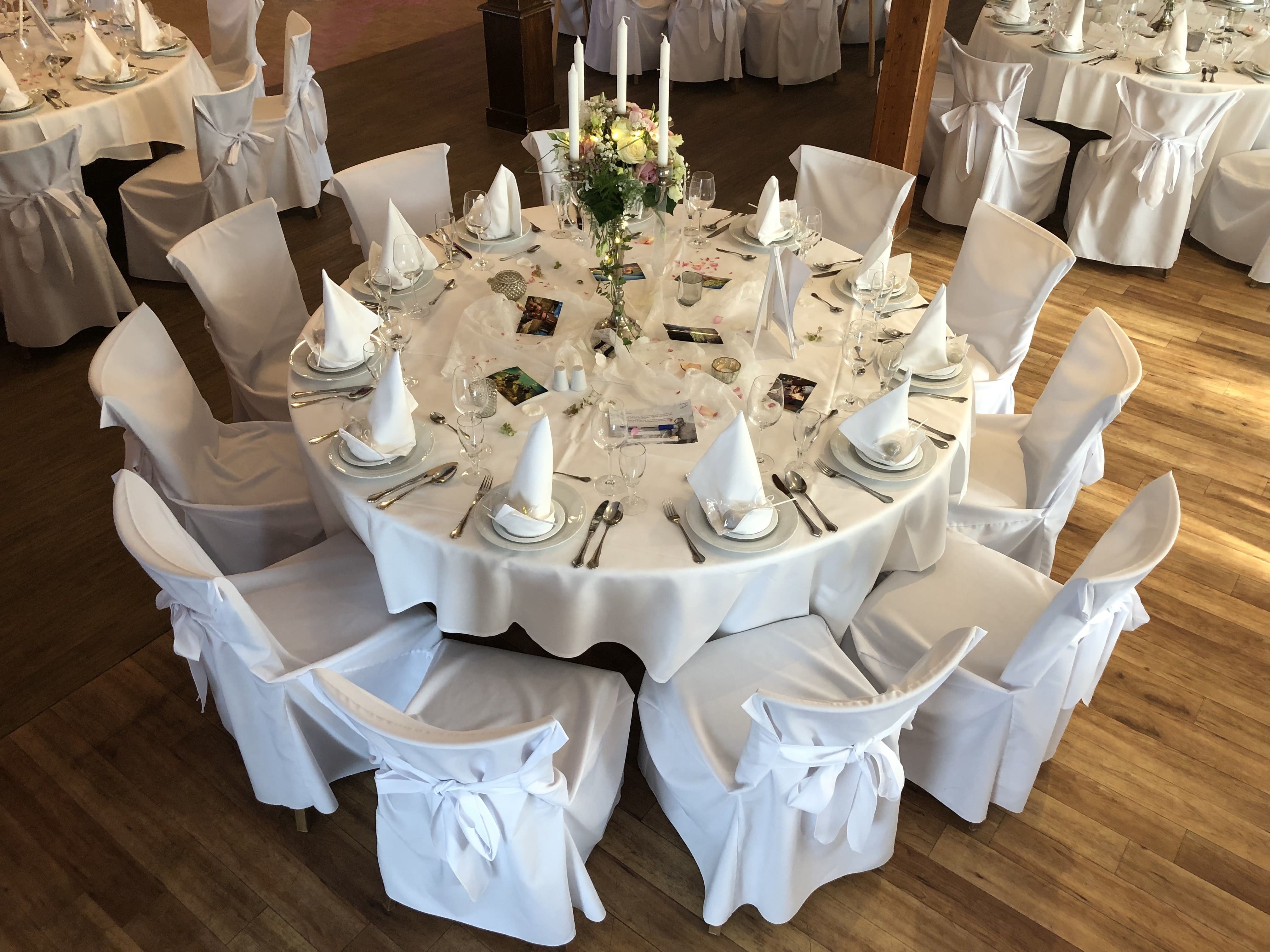 Gedeckter runder Tisch in weiß. 