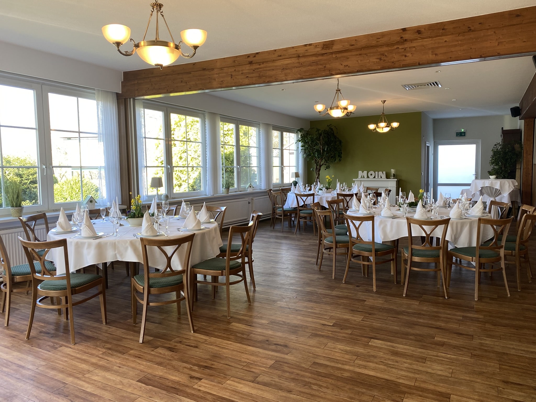 Kleiner Veranstaltungsraum mit drei Runden Tischen.