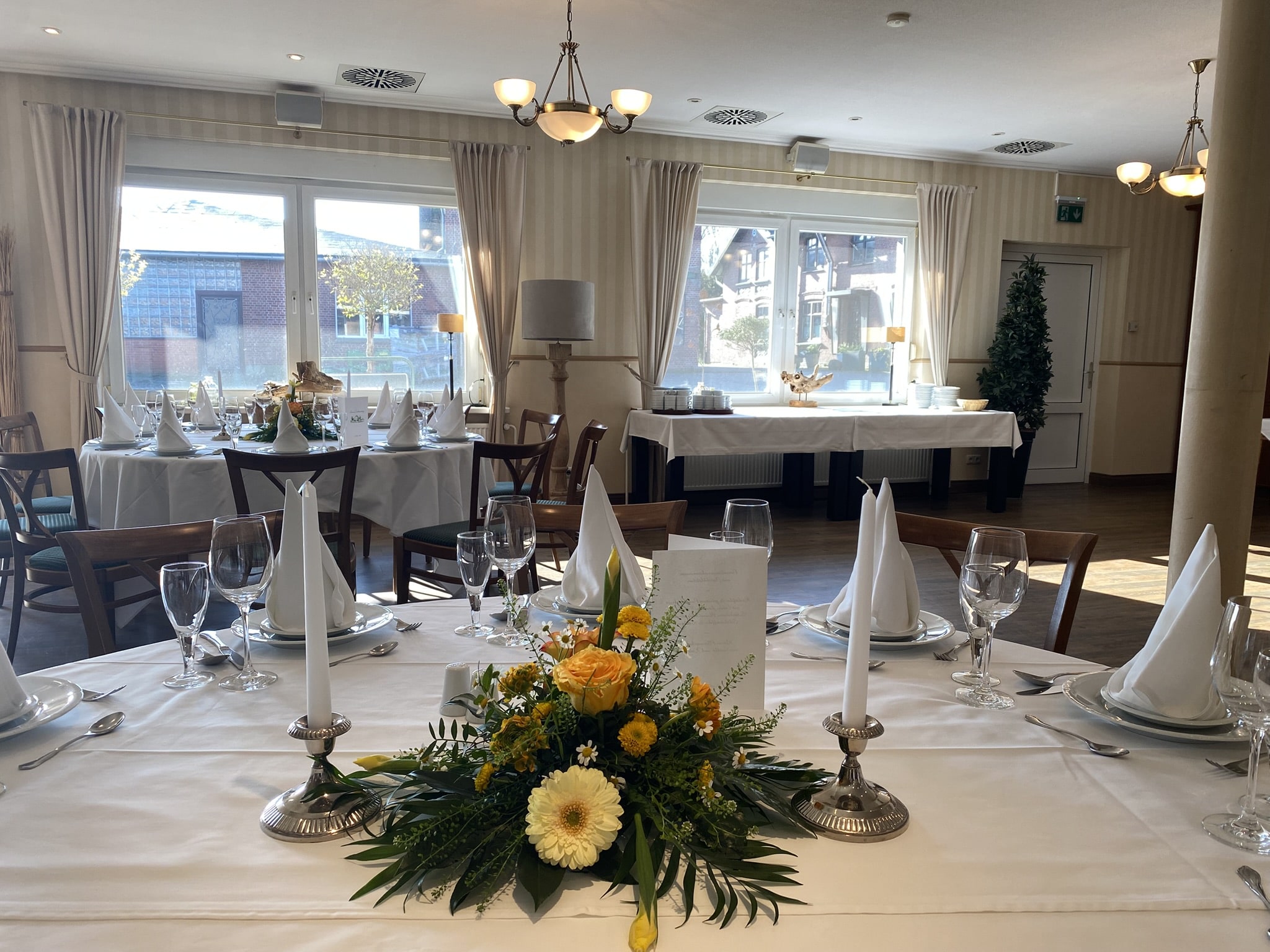 Veranstaltungssaal mit festlich gedecktem Tisch.